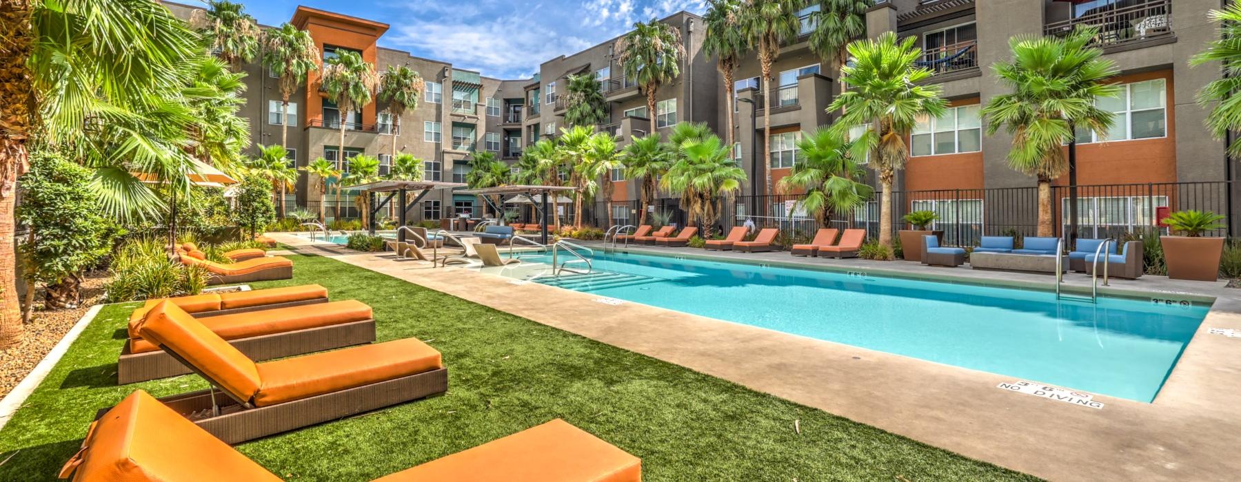 a pool with lounge chairs and a building in the background